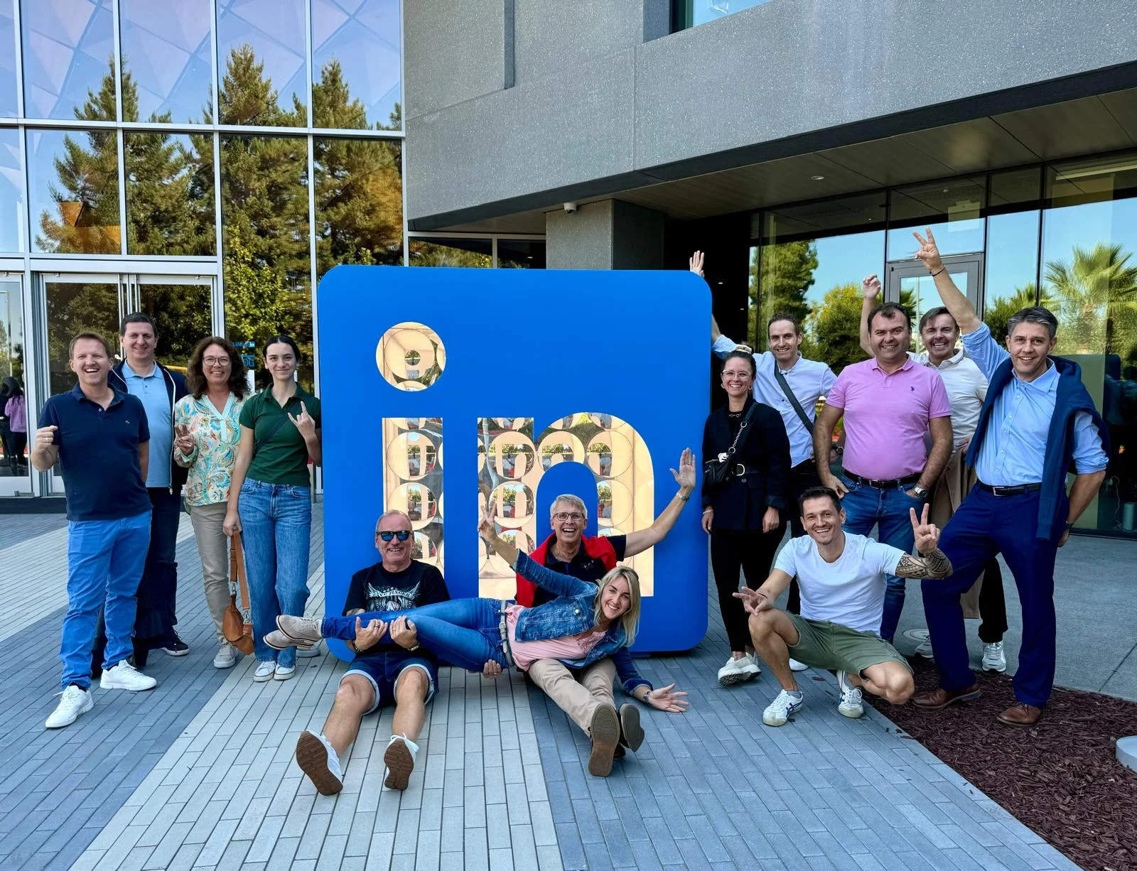 Unternehmergruppe vor LinkedIn-Logo, fröhlich und entspannt.