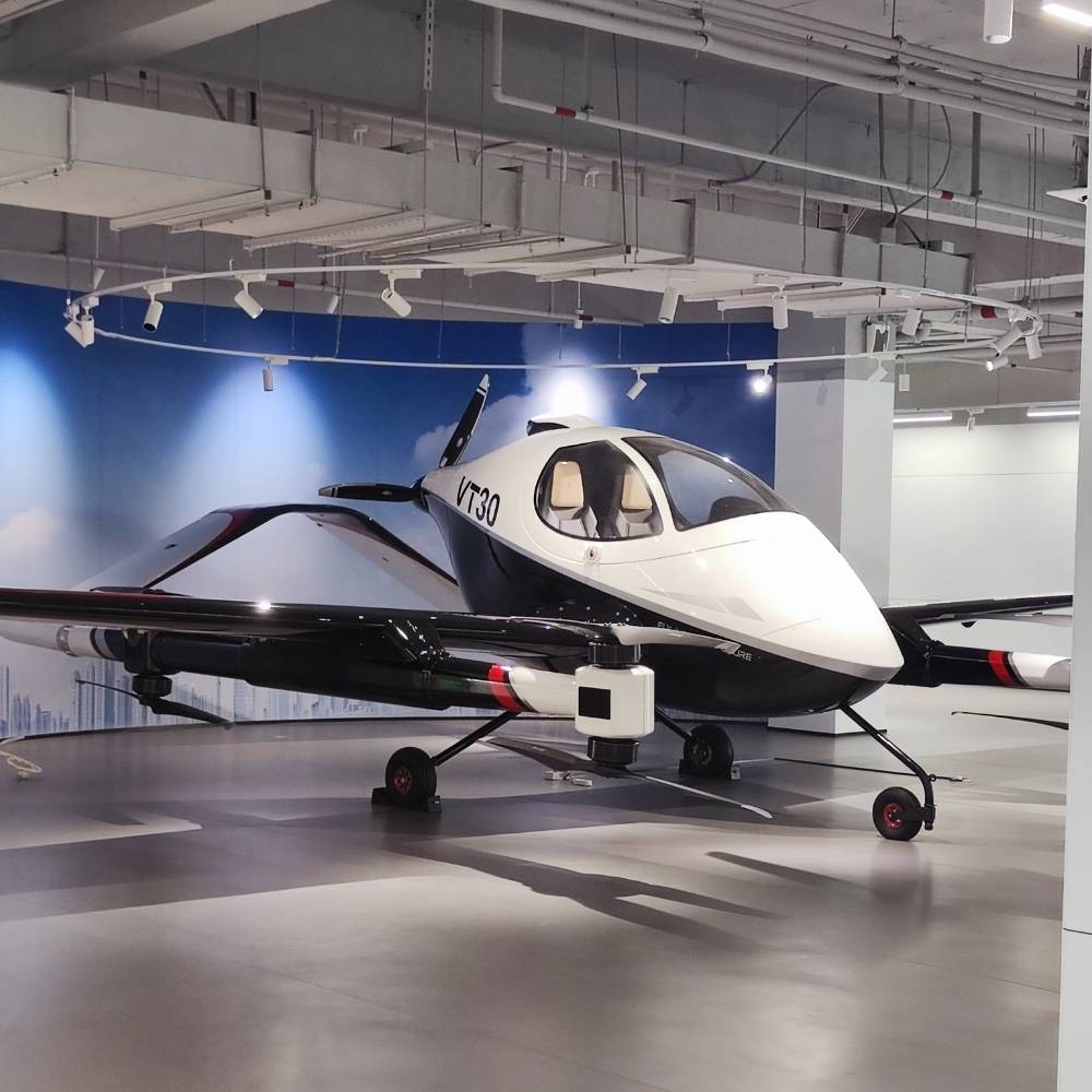 Futuristisches wei&szlig;-schwarzes autonomes Flugtaxi (eVTOL) Modell VT30 in einer High-Tech-Ausstellungshalle in Guangzhou, China &ndash; Symbol f&uuml;r urbane Luftmobilit&auml;t.