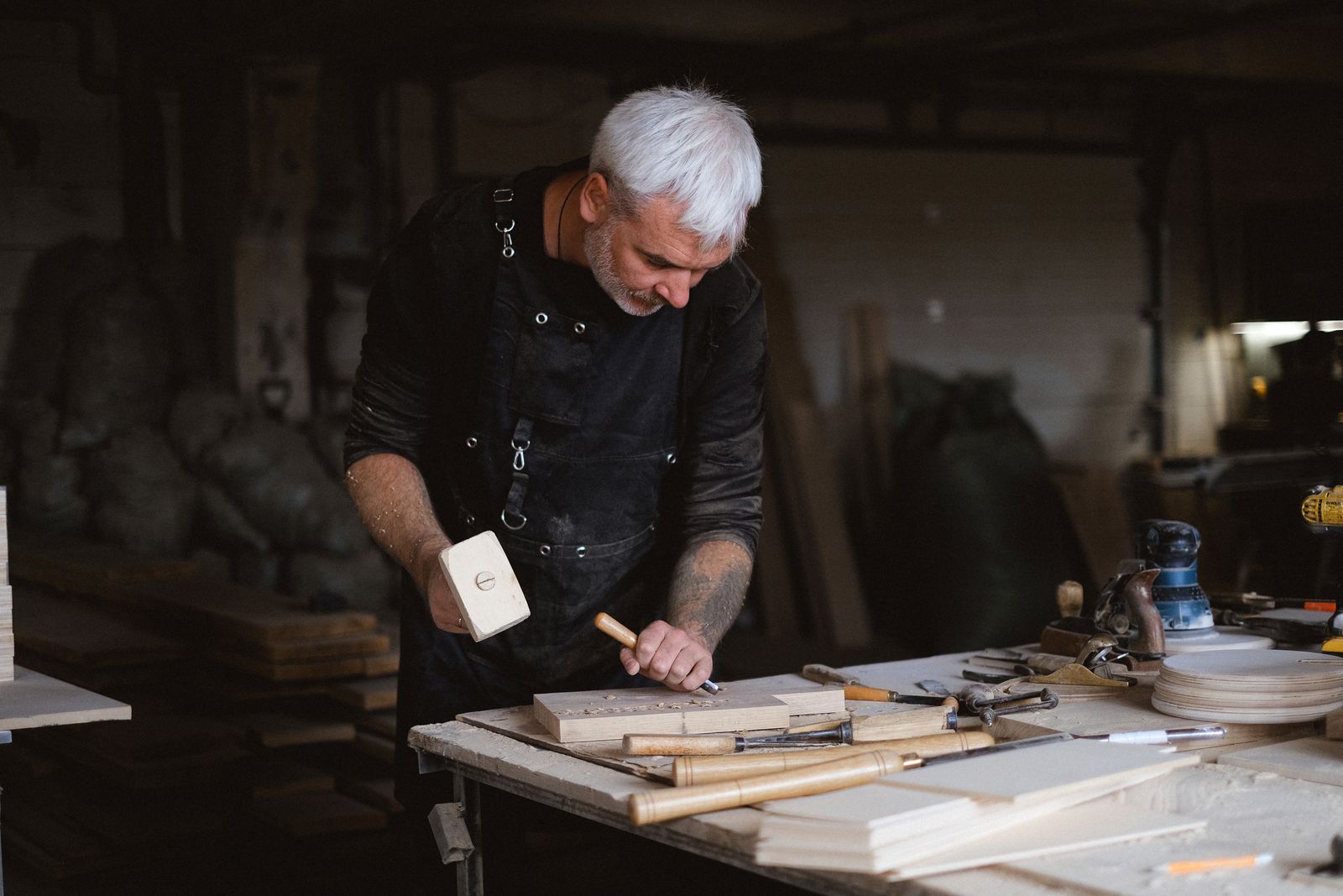 Handwerker bearbeitet ein Werkstück aus Holz in der Werkstatt